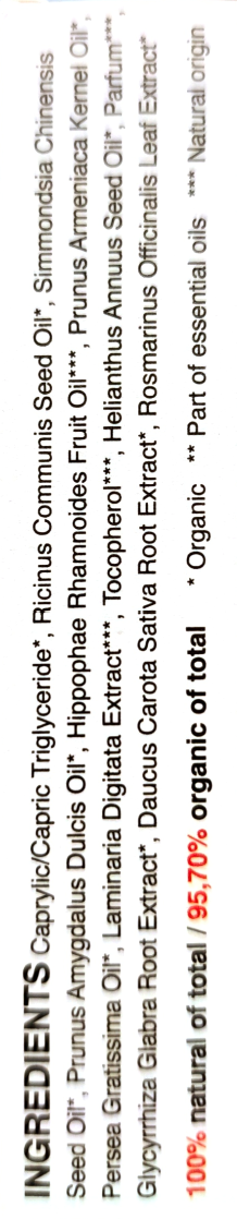 A close-up of a product label showing the ingredients list in English, including caprylic/capric triglyceride, ruminus communis seed oil, Simmondsia chinensis seed oil, and other natural ingredients, with a white background.