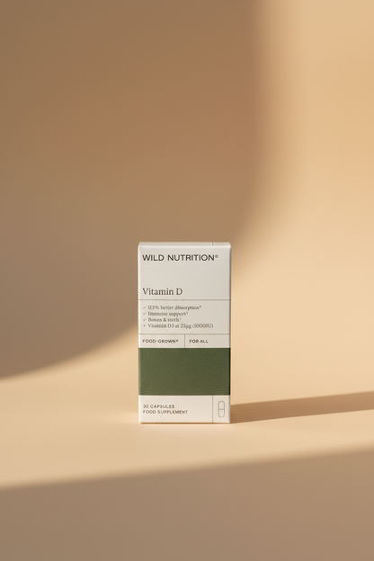Wild Nutrition Vitamin D supplement box in white and dark green packaging, photographed on a wooden tabletop.