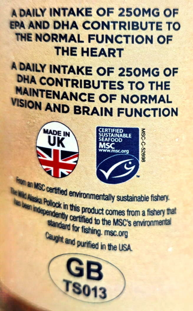 Close-up of a beige food package label with black text about daily EPA and DHA intake, plus a UK Made in UK badge, an MSC certified sustainable seafood logo, and a GB TS013 mark.