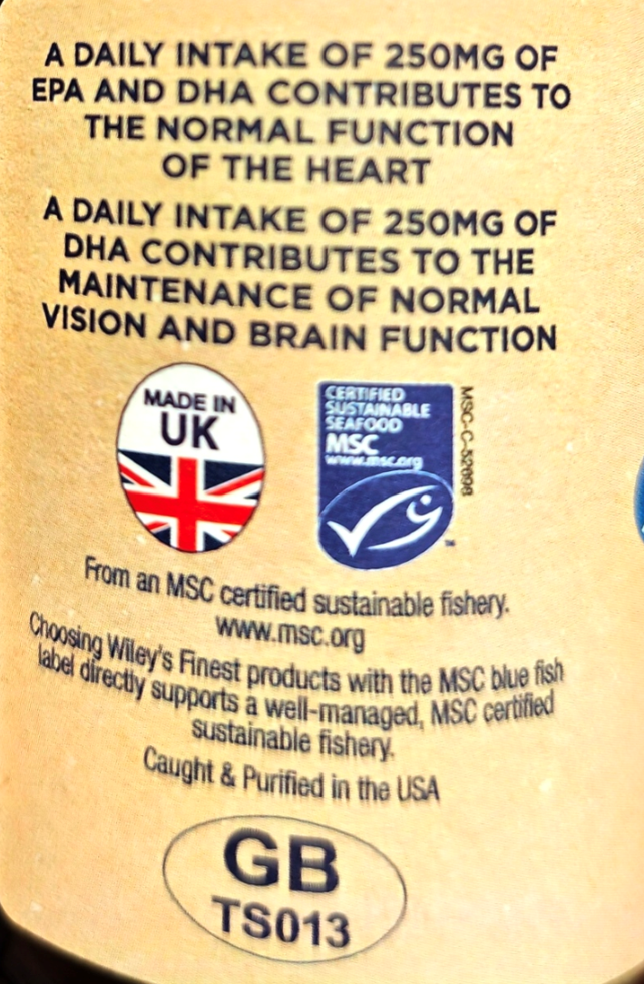 Close-up of a beige product label with black text about EPA and DHA intake, a 'Made in UK' badge with the Union Jack, and an MSC certified sustainable fishery logo.