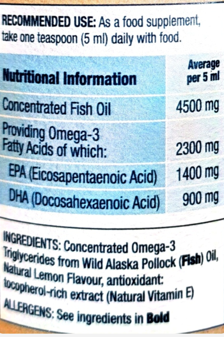 Close-up of a supplement label showing recommended use and nutritional information for concentrated fish oil, including amounts per 5 ml and ingredients listed below.